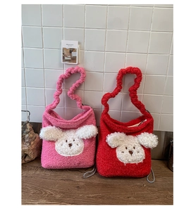 Detail view of plush puppy bucket bags in red and pink with 3D cute animal faces