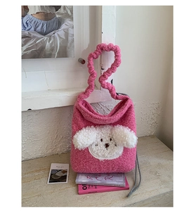 Detail of pink plush bucket bag featuring a 3D puppy design and soft sherpa texture