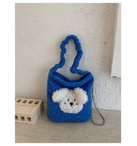Detail of blue plush bucket bag with cute dog patch and ruched handle texture