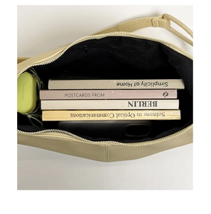 Top view showing the spacious interior of the beige tote bag with books and umbrella