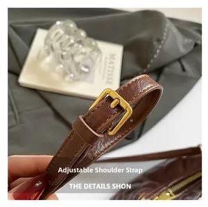 Detailaufnahme des verstellbaren Schultergurts mit Bronzeschnalle an der Stepptasche