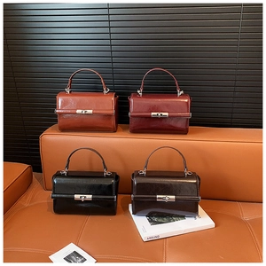 Detail view of four glossy vintage-style leather tote bags with metal twist locks