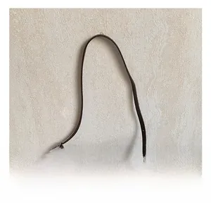 Détail d'un sac seau en cuir marron foncé avec poignée et texture grainée élégante