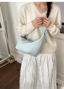 Close-up of light blue lychee pattern leather hobo bag with unique knot shoulder strap