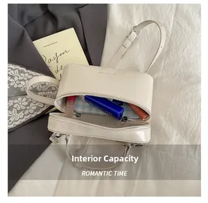 Capacité interne du sac cylindrique en cuir beige minimaliste avec cosmétiques et accessoires