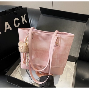 Dettaglio della borsa tote a scacchi rosa con ciondolo a orsetto e confezione regalo