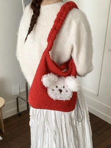 Cute red plush puppy bucket bag with drawstring, worn by model for casual commute