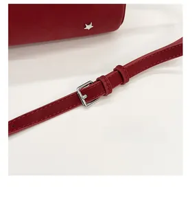Detail of red baguette bag with textured faux leather and adjustable silver metal buckle