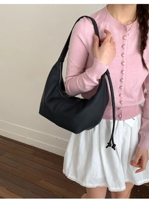 Close-up of black lychee grain crescent hobo bag with stylish side knot detail