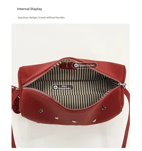 Detail view of red rivet handbag featuring star studs and striped lining with zipper pocket