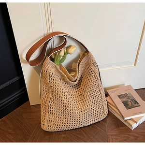 Detail of hand-woven hobo bag with brown leather strap and intricate knit texture