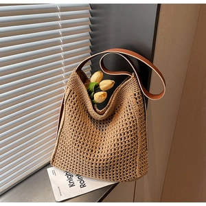 Detail of hollow woven tote bag with brown leather straps and interior tulip decor