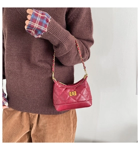 Détail du sac à main en cuir matelassé bordeaux avec chaîne dorée et fermoir pivotant