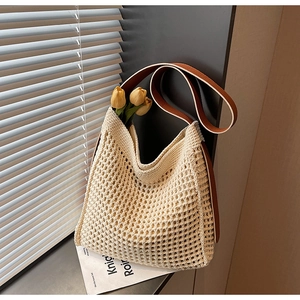 Detail of hollow woven tote bag with brown leather strap and soft fabric lining