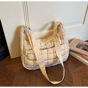 Détail de la bandoulière réglable et texture matelassée du sac beige