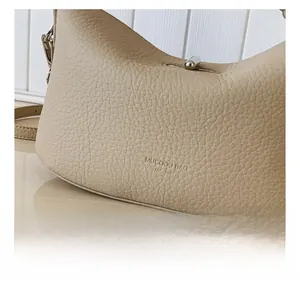 Detail of apricot lychee pattern leather handbag with metal twist lock and embossed logo