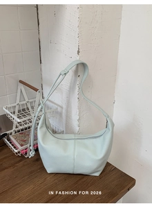 Macro view showing the lychee leather texture of the mint green crescent hobo bag