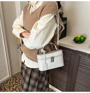 Sac boîte blanc structuré chic porté par un mannequin avec une tenue rétro chic