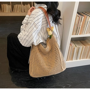 Close-up of woven tote bag with hollow crochet texture and brown leather strap
