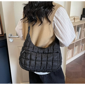 Détail d'un sac bouffant noir matelassé avec bandoulière réglable et détails métalliques