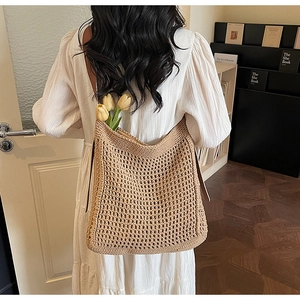 Detail of a large woven straw tote bag with flowers during a vacation photoshoot