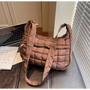 Détail d'un sac dumpling marron matelassé en nylon rembourré avec fermetures à glissière