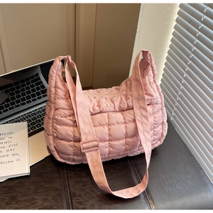 Détail du sac à bandoulière matelassé rose en nylon souple avec une sangle réglable