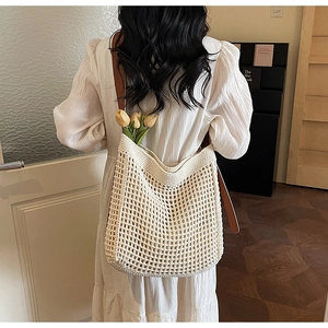 Detailed view of beige crochet tote bag with brown leather straps and tulip decor