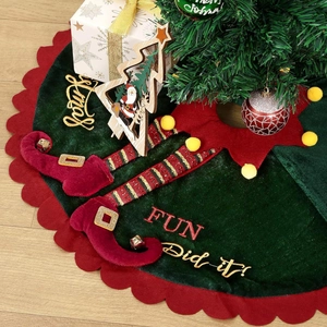 Dark green velvet Christmas tree skirt with elf legs, scalloped red edges and pom poms