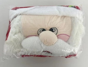 Detail showing Santa Claus plush pillow with white beard in plastic protective packaging