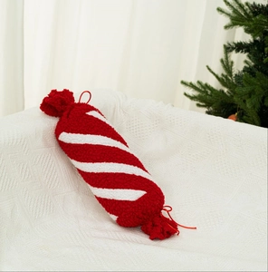 Dettaglio del cuscino di peluche a forma di caramella a strisce bianche e rosse