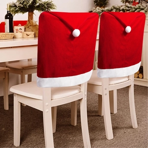 Detail of red Santa hat chair covers with white pom-poms for Christmas dining decor