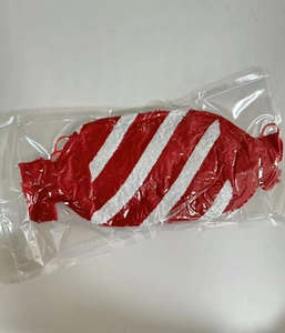 Dettaglio del cuscino di peluche a strisce bianche e rosse in confezione trasparente
