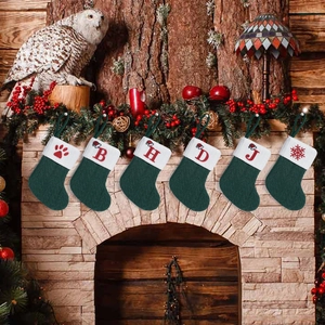 Set of 6 dark green knit Christmas stockings with alphabet embroidery and fireplace decor