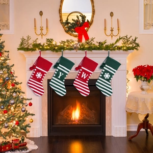 Detail view of four festive striped Christmas stockings hanging by a cozy fireplace
