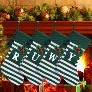 Detail of green and white striped knit Christmas stockings with custom alphabet letters