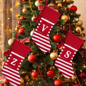 Three red Christmas socks with white stripes and letters Z, V, S on a festive tree