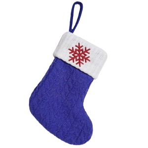 Blue knitted Christmas stocking with white cuff and red embroidered snowflake pattern