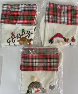 Detailed view of Christmas stocking gift bags with reindeer, Santa, and penguin embroidery