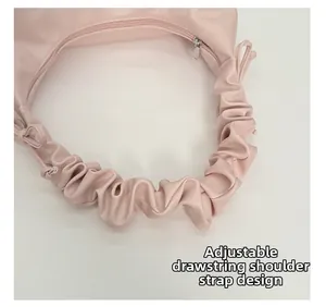 Close-up of adjustable drawstring shoulder strap detail on a pink ruched handbag