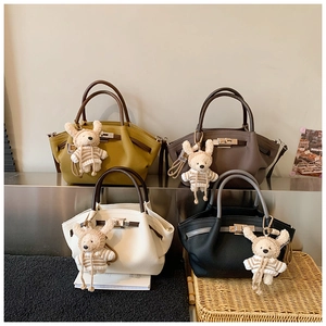 Detail of four retro leather handbags with metallic twist locks and cute rabbit charms
