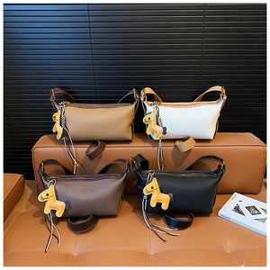 Détail de sacs à bandoulière minimalistes en cuir en quatre couleurs avec breloque
