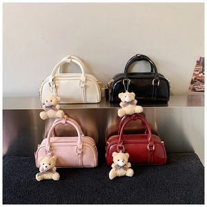 Detail of Boston bags in four colors with smooth wrinkled leather and plush bear charms