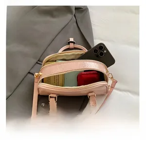 Detailed interior of pink textured pillow bag showing capacity for phone and cosmetics
