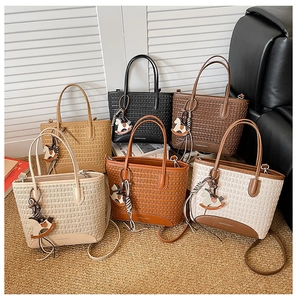 Dettaglio borse shopper intrecciate in sei colori con ciondoli e tracolla staccabile