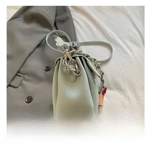 Detailansicht der silbernen Hardware-Kette und des matten Leders der hellblauen Umhängetasche