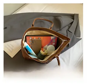 Interior view of brown faux leather tote bag showing large capacity and zipper pocket