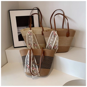 Three straw tote bags with leather straps and floral lace scarves on white steps