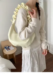 Close-up of the pleated cloud-like shoulder strap on a cream crescent handbag for women