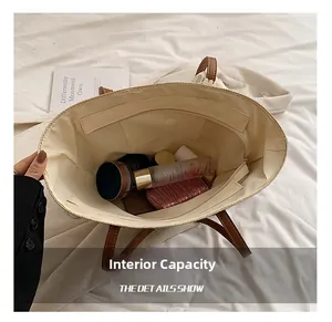 Internal view of large straw tote bag showing spacious compartments and zip pockets